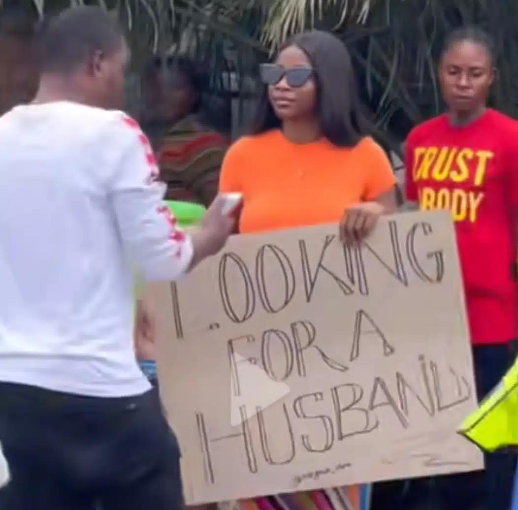 “Looking for a husband” – Lady displays placard, walks into street in search for life-partner (Video)